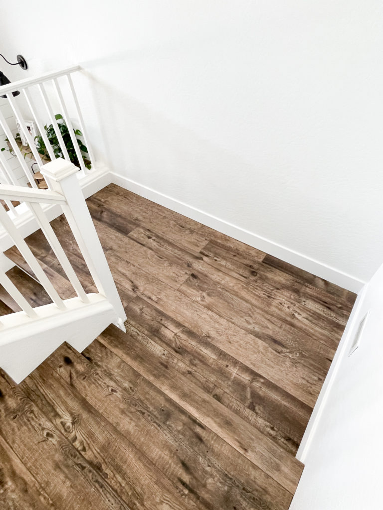 Lvp on stairs whit white risers - RE Flooring, Llc